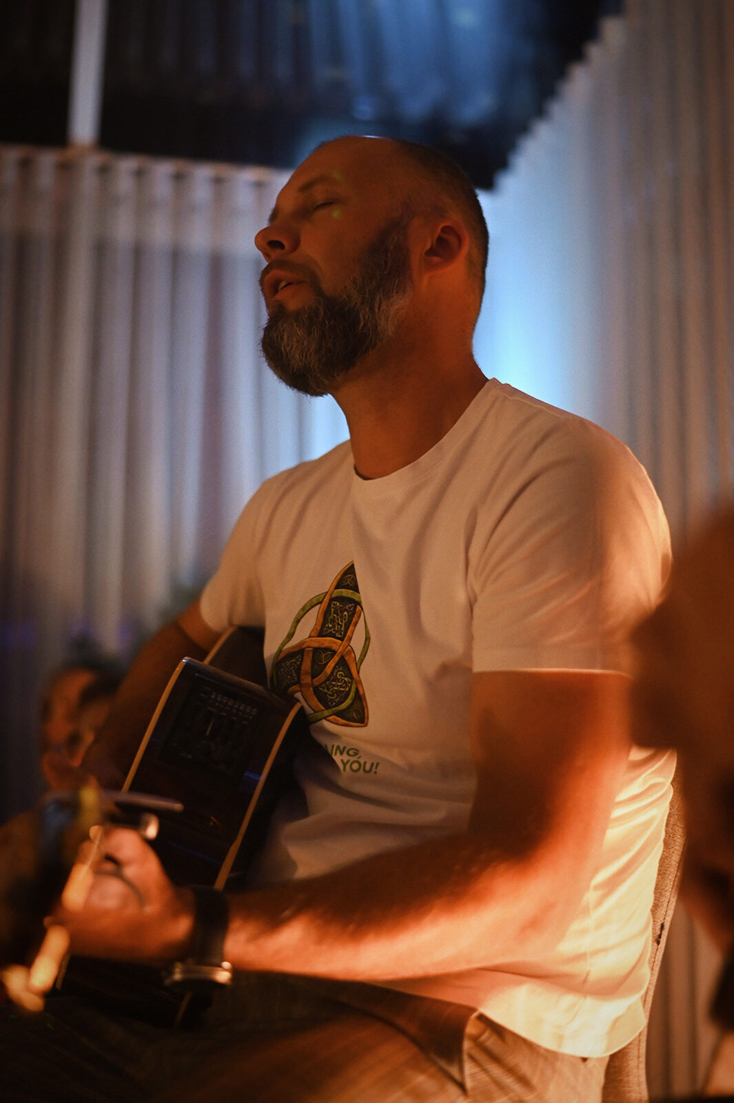 Mūziķis ar ģitāru kirtana vakarā